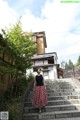 A woman is standing on the steps of a building.