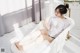 A woman sitting in a bathtub with bubbles in it.