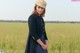 A woman standing in a field of yellow flowers.