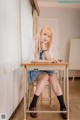 A woman sitting at a desk in a classroom.