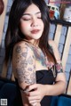 A woman with a tattoo on her arm is posing for a picture.