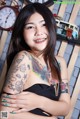 A woman with tattoos on her arms posing for a picture.