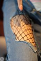 A woman wearing fishnet stockings and a pair of jeans.