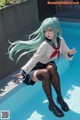 A woman in a school uniform sitting on the edge of a pool.