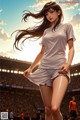 A woman in a white shirt and shorts standing in front of a stadium.