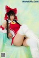 A woman in a red and white outfit is posing for a picture.