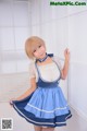 A woman in a blue and white dress posing for a picture.