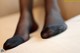 A close up of a person's feet in black stockings.