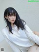 A woman with long black hair wearing a white shirt.