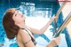 A woman in a black bikini standing next to a swimming pool.