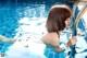 A woman in a black bikini in a swimming pool.