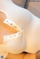 A close up of a woman wearing a white bodysuit.