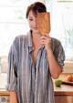 A woman holding a wooden spatula in a kitchen.