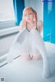 A woman sitting on a window sill wearing white stockings.