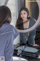 A woman looking at herself in the mirror.