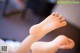 A close up of a person's bare feet on a bed.