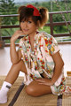 A woman in a kimono sitting on a bamboo mat.