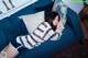 A woman laying on a blue couch in a living room.