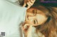 a woman laying on top of a bed wearing a white shirt