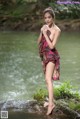 A woman standing on a rock in the water.