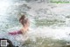 A little girl in a pink dress is swimming in the water.