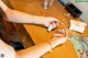 A woman sitting at a table with a remote control in her hand.