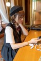 A woman sitting at a table looking at her phone.