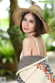 A woman wearing a straw hat is posing for a picture.