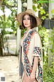 A woman wearing a straw hat and a colorful kimono.