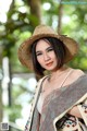 A woman wearing a straw hat and a colorful shawl.