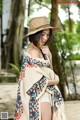 A woman wearing a straw hat and a blanket.