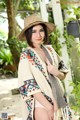 A woman wearing a straw hat and a colorful shawl.