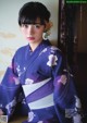 A woman in a purple kimono sitting on a table.