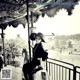 A woman in a hat is sitting on a carousel.