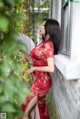 A woman in a red dress holding a fan.