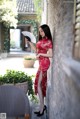 A woman in a red dress holding a fan.